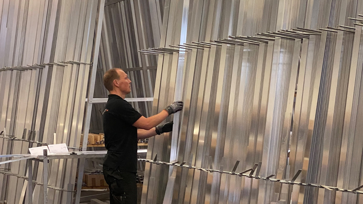 Männliche Person greift im Lager nach Aluminium in 6 Meter Länge