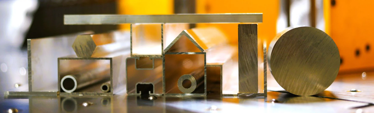 verschiedene Aluminium-Profile nebeneinander sowie übereinander. U. a. Rundprofil, Systembauprofil und U-Profil