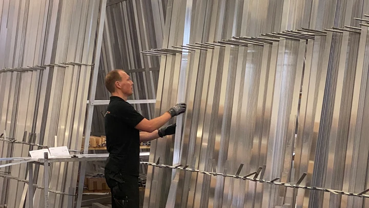 Nils Vespermann prüft Aluminiumprofile am Lagerregal